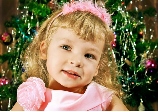 Portrait of young girl in pink on background Christmas trees — Stock Photo, Image