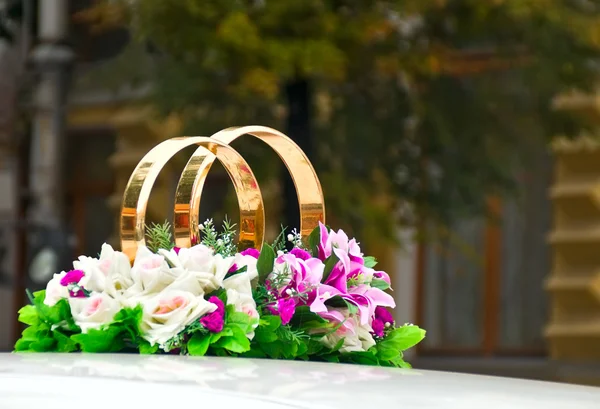 Rings with flowers at wedding car — Stock Photo, Image