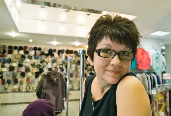 Positive Woman in store hats — Stock Photo, Image