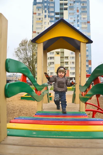 Mały chłopiec wspina się drabiny na placu zabaw na dziedzińcu — Zdjęcie stockowe