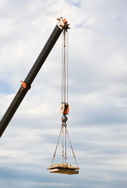 Charge suspendue sur la flèche d'une grue — Photo