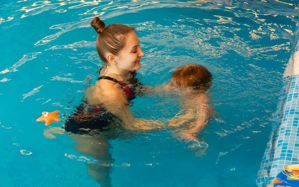 Mum learns kid to float in pool — Stock Photo, Image