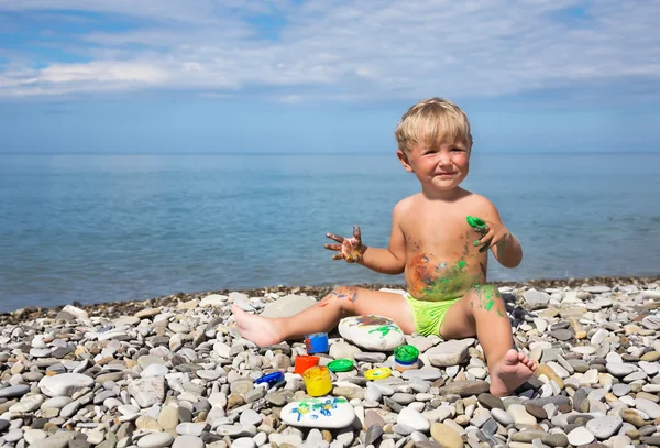 Criança suja por tintas na praia — Fotografia de Stock