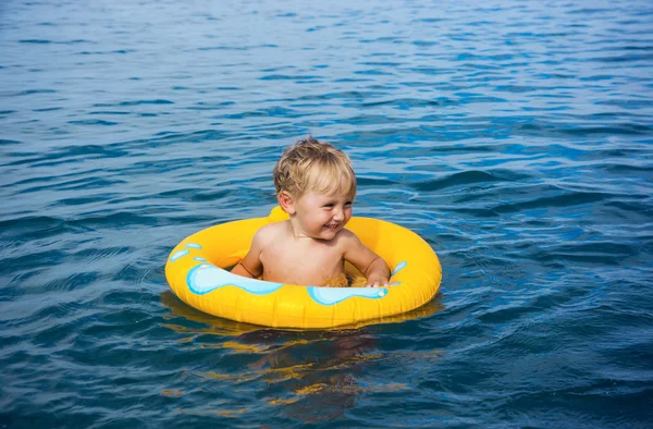 Kleine jongen in water op Rubberring — Stockfoto