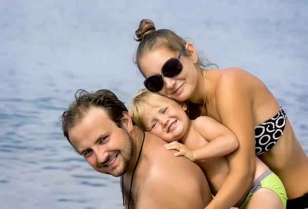 Happy young family with small son on beach — Stock Photo, Image