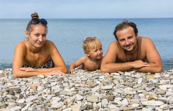 Mladá rodina tři osoby na pláži — Stock fotografie
