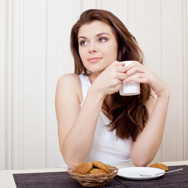 Hermosa mujer disfrutando del té y galletas —  Fotos de Stock