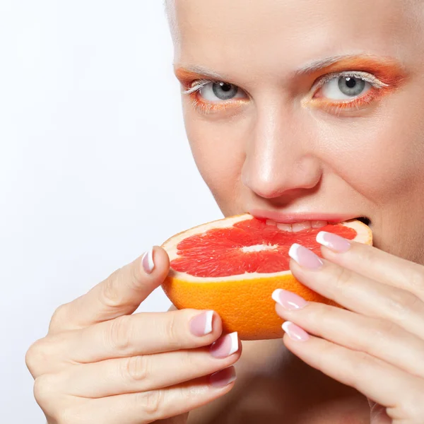 Vrouw met creatieve make-up en grapefruit — Stockfoto