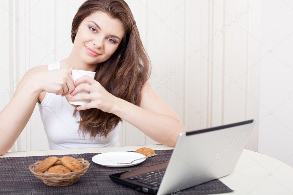 Happy woman enjoying tea and cookies