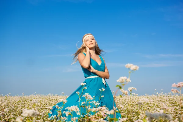 Hermosa mujer caminando en el campo de flores — Foto de Stock