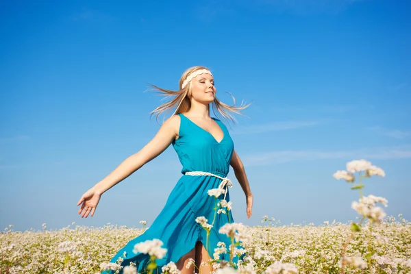 Mooie vrouw lopen op bloem veld — Stockfoto