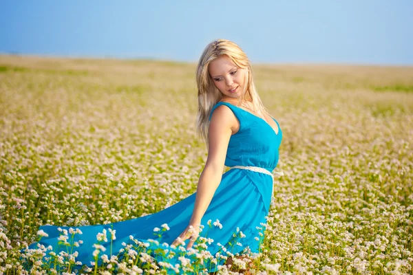 Bella donna che indossa un vestito blu su un campo — Foto Stock