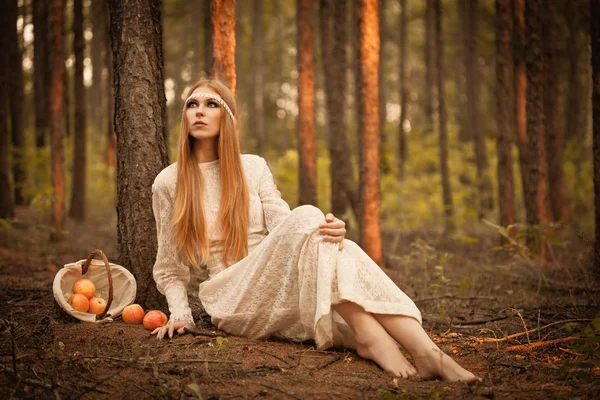 Kobieta siedzi na ziemi w lesie — Zdjęcie stockowe