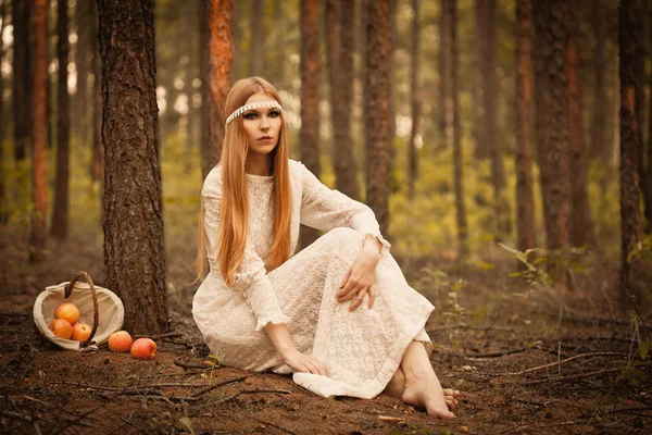 Woman sitting on ground in the forest — Stock Photo, Image