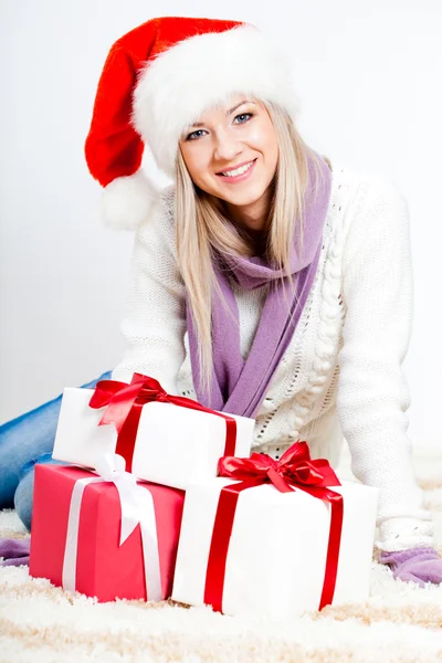 Жінка в капелюсі Санта сидить на підлозі — стокове фото