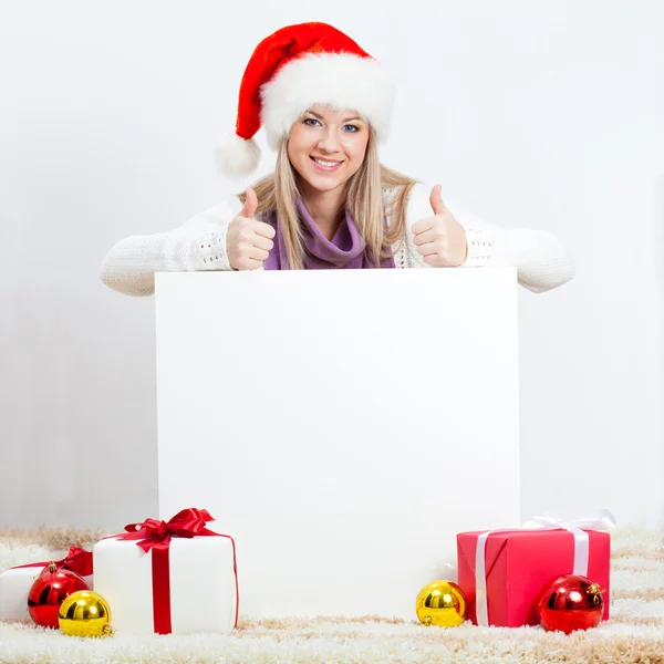 Woman wearing santa hat sitting on the floor — Stock Photo, Image