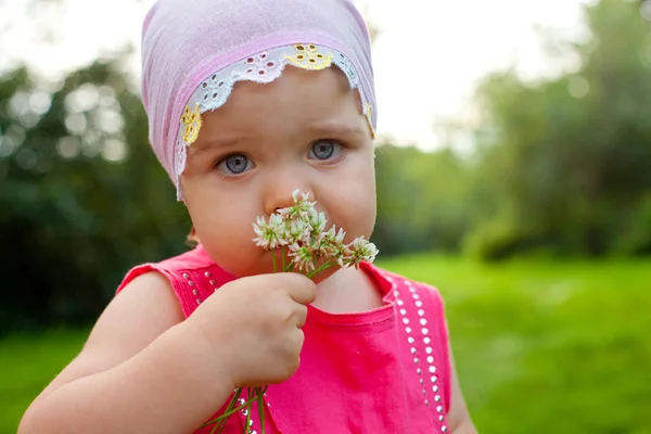 Little girl holding flowers — Stock Photo, Image