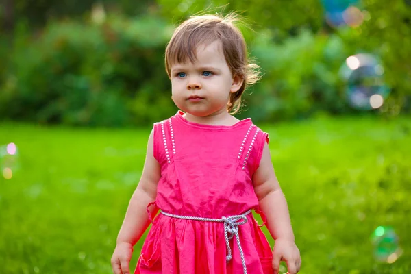 Klein meisje in het park met bubbels — Stockfoto