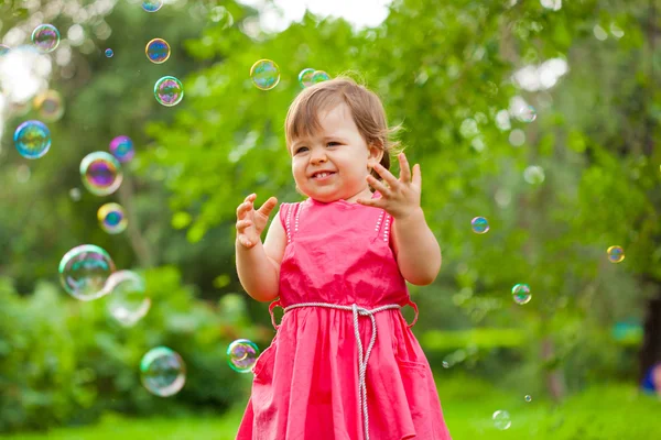 Petite fille au parc avec des bulles — Photo