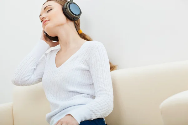 Vrouw op de Bank luisteren naar muziek Stockfoto