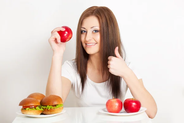 Vrouw zitten achter de tafel met voedsel — Stockfoto