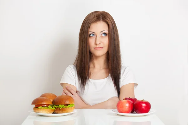 Mujer sentada detrás de la mesa con comida —  Fotos de Stock