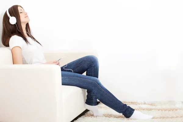 Kobieta siedzi na kanapie i patrząc na gracza — Zdjęcie stockowe