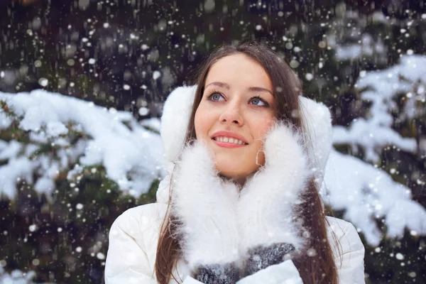 Красивая брюнетка, стоящая под снегом — стоковое фото