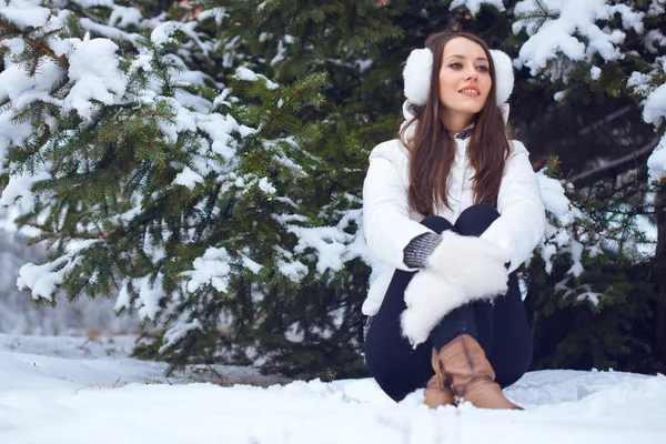 Женщина сидит в зимнем парке — стоковое фото