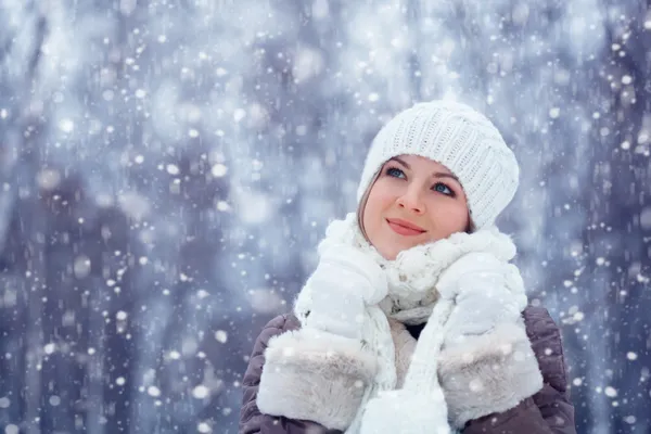 Beautiful woman walking outdoors under snowfall — Stock Photo, Image