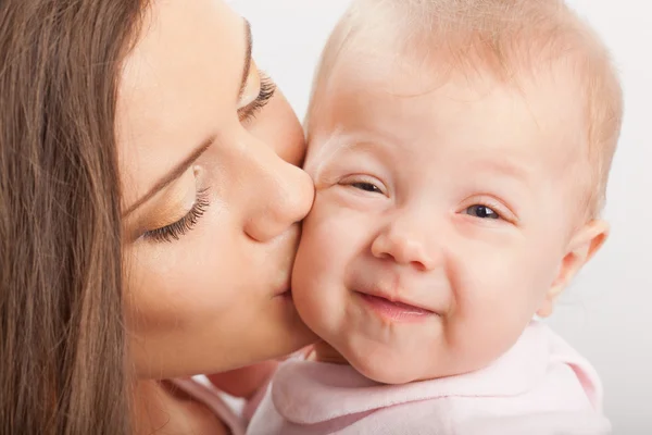 Mãe beijando bebê menina — Fotografia de Stock