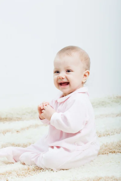 Babymeisje, zittend op het tapijt — Stockfoto