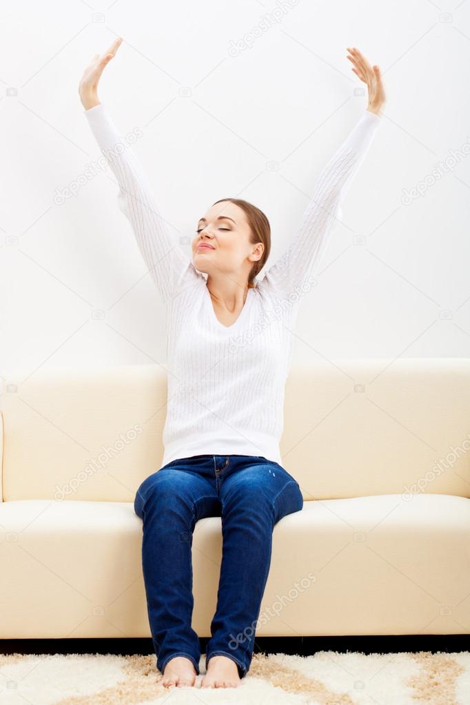 Happy woman sitting on sofa
