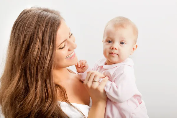 Junge Mutter hält ihr kleines Mädchen auf Händen — Stockfoto