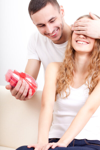 Мужчина дарит коробку в форме сердца своей девушке
