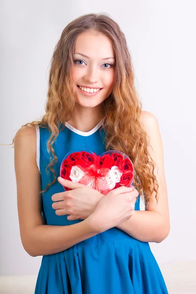 Mujer joven sosteniendo caja en forma de corazón — Foto de Stock