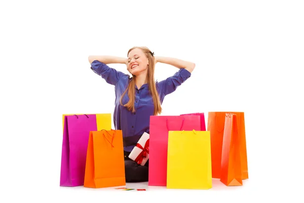 Mujer sentada en el suelo detrás de bolsas de compras —  Fotos de Stock