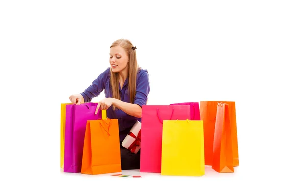 Mujer sentada en el suelo detrás de bolsas de compras —  Fotos de Stock