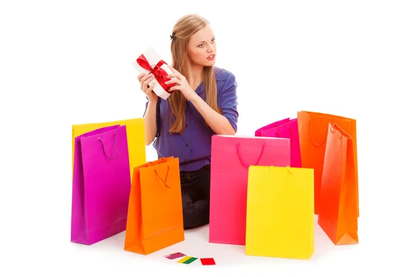Vrouw zittend op de vloer achter shopping tassen — Stockfoto