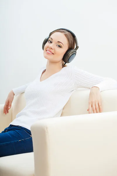 Mulher no sofá ouvindo música — Fotografia de Stock