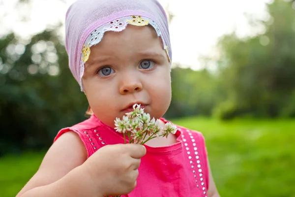 小さな女の子は花を持つ — ストック写真