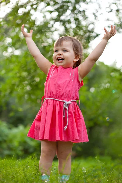 Маленькая девочка поднимает руки — стоковое фото