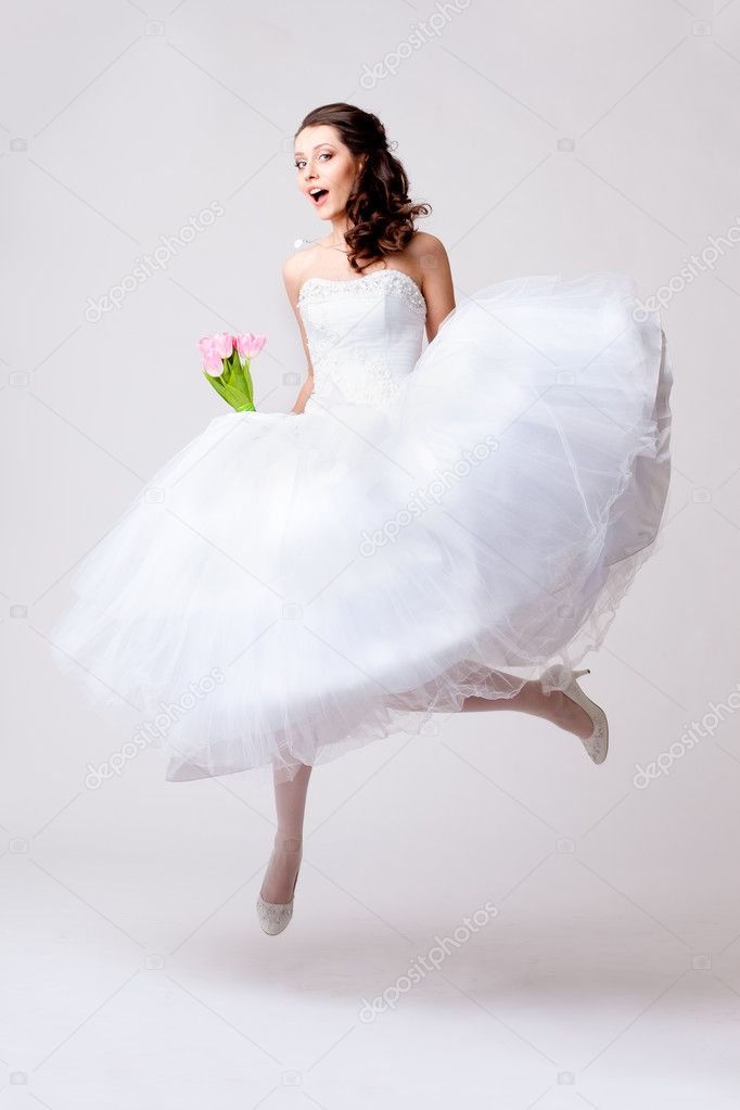 Beautiful bride jumping in studio