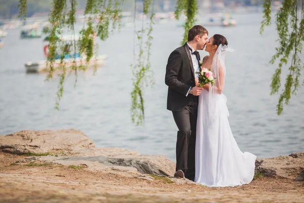 Brudparet står nära sjön — Stockfoto