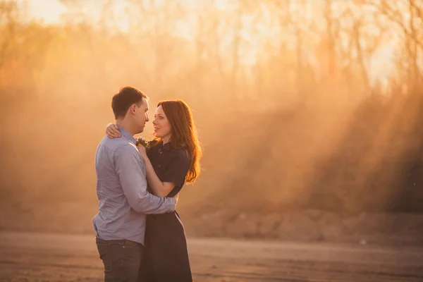 Couple embracing standing on the road in the dust — Stock Photo, Image