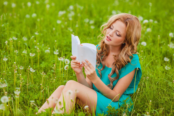 Serious woman reading book outdoors