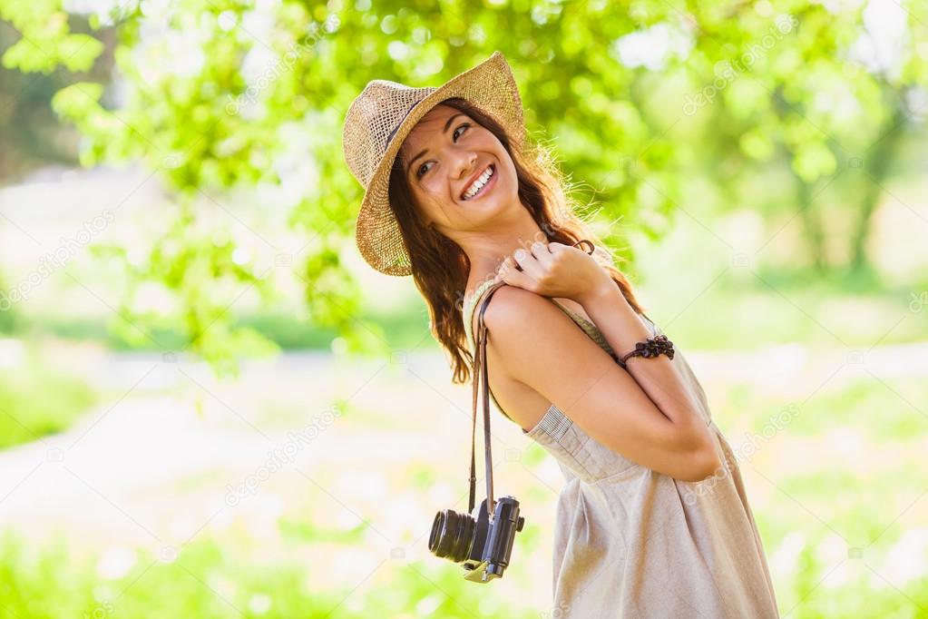 Happy young girl with camera outdoors