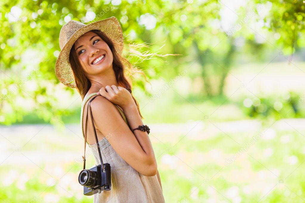 Happy young girl with camera outdoors
