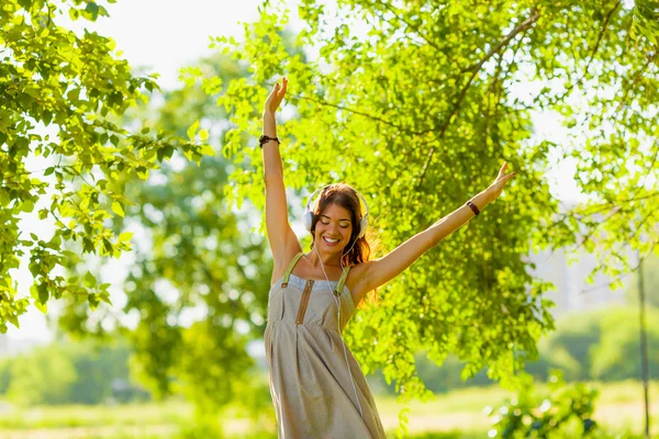 Glad tjej bär hedphones utomhus — Stockfoto