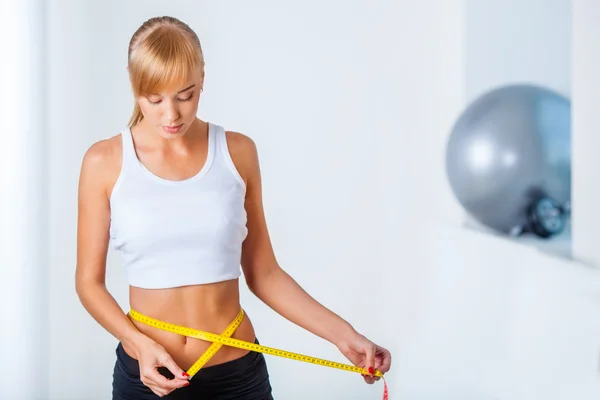 Woman measuring her waistline — Stock Photo, Image